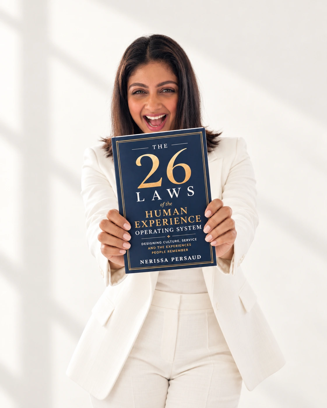 Nerissa Persaud holding The 26 Laws, wearing a white suit
